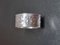 Entdecken Sie unseren silberner Ring mit markanten Hammerschlag.Die strukturierte Mitte wird von zwei schmalen, glatten Rändern eingefasst.