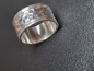 Entdecken Sie unseren silberner Ring mit markanten Hammerschlag.Die strukturierte Mitte wird von zwei schmalen, glatten Rändern eingefasst.