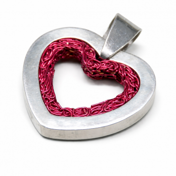 Unser Kettenanhänger Amore ist in Herzform aus einem Draht mit spezieller Verarbeitung und freier Kettenführung hergestellt. Das Drahtherz wurde in einem Separaten Silberherzrahmen aus Silber 935 frei eingefasst und ist wechselbar. Der Anhänger ist durch