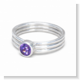 Auf dem Bild ist ein Bandring mit 3 Bänder aus 935 Silber und einem synthedischen Kunzit in Brillantschliff zu sehen.